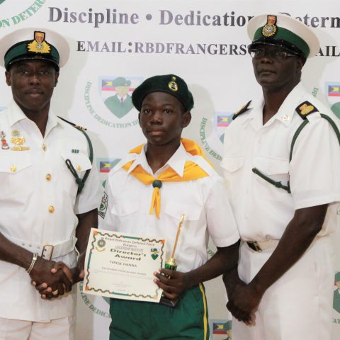 Tyrese Hanna of Sister Mary Patricia School, receiving the Rangers Director Award at the RBDF Rangers Passing out Parade ceremony in Grand Bahama on May 11, 2019. overall Minister of National Security Award. Also shown are: Lieutenant Commander Johnson, the commanding officer of the RBDF Freeport Base and Rangers Operations Senior Rate, Chief Petty Officer Pedro Bain.