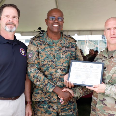 Commander Frederick Brown receiving a plaque from US Army Lieutenant Colonel Brian Horvath as a token of the Royal Bahamas Defence Force participation in the recent “OPERATION MARLIN SHIELD” exercise from May 17th – 24th. The closing ceremony  was held at the Defence Force Base on May 24th. Standing at left is Scott Eddy, US Representative.